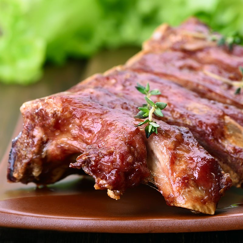 Pork Rack of Ribs Covered in BBQ Sauce and Thyme